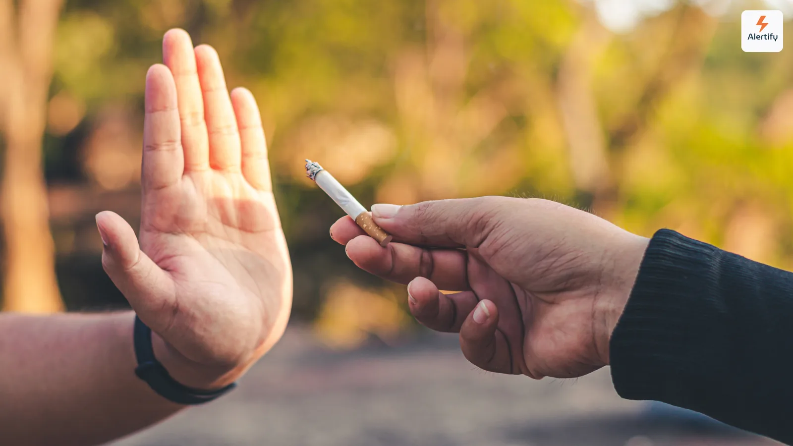 Χέρι σηκωμένο για να αρνηθεί ευγενικά ένα αναμμένο τσιγάρο που προσφέρει άλλο άτομο σε εξωτερικό χώρο